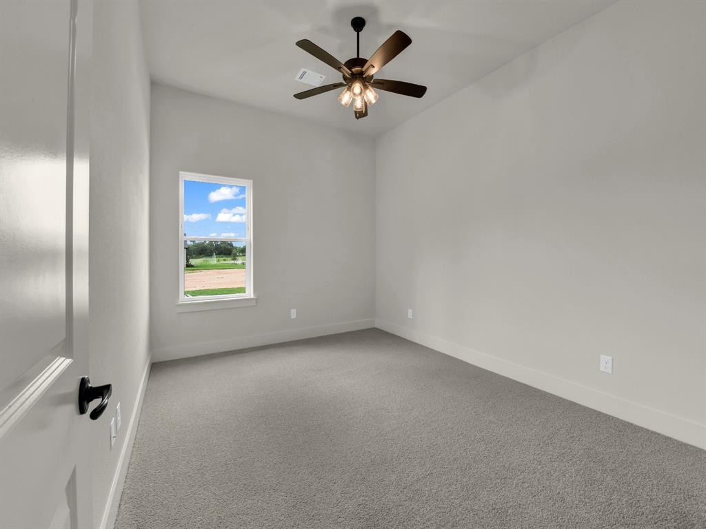 305 Wrangler Court Weatherford, TX 76088 - Photo 32 of 32 an empty room with window and a ceiling fan