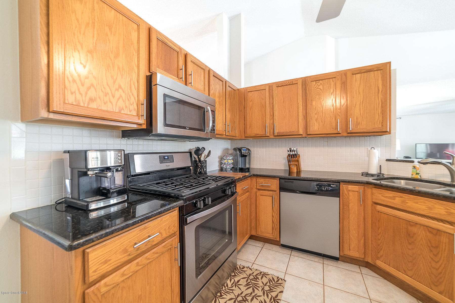 3475 Shady Run Road Melbourne, FL 32934 - Photo 22 of 38 a kitchen with stainless steel appliances granite countertop a stove a sink and a microwave