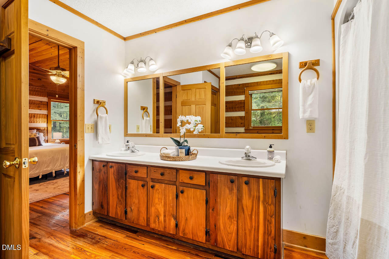 1114 Phil's Ridge Road Chapel Hill, NC 27516 - Photo 22 of 52 a bathroom with a double vanity sink and a mirror