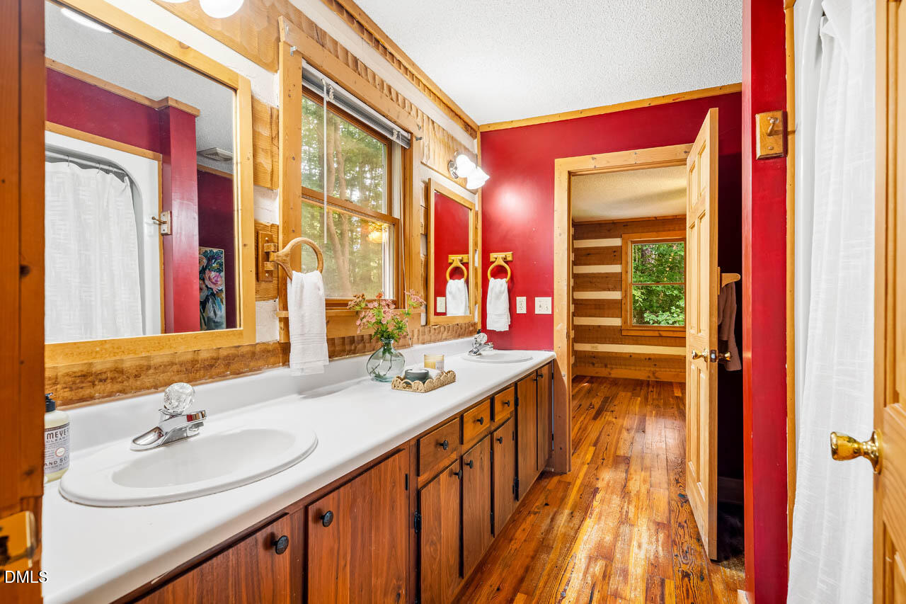 1114 Phil's Ridge Road Chapel Hill, NC 27516 - Photo 26 of 52 a bathroom with a sink a mirror and a shower