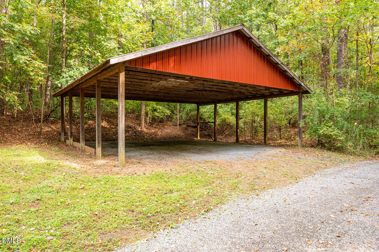 1114 Phil's Ridge Road Chapel Hill, NC 27516 - Photo 49 of 52 a backyard of a house with table and chairs under an umbrella