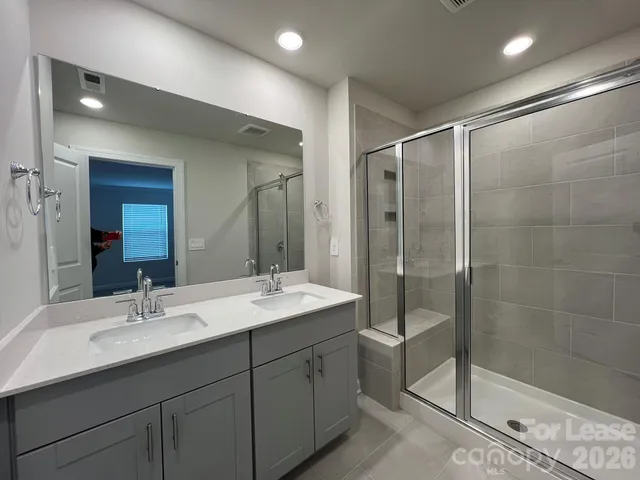 a bathroom with a shower sink and mirror