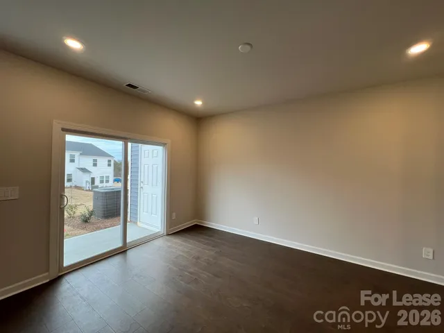 an empty room with wooden floor and mirror