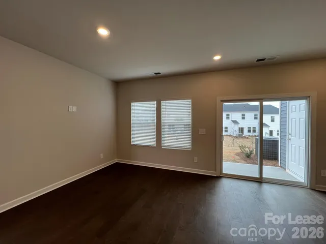 an empty room with wooden floor and sliding door