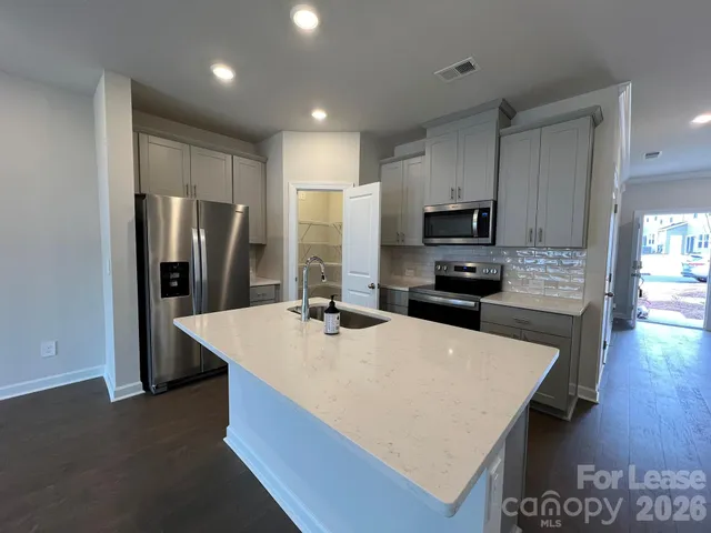 a kitchen with stainless steel appliances a refrigerator microwave stove sink and cabinets