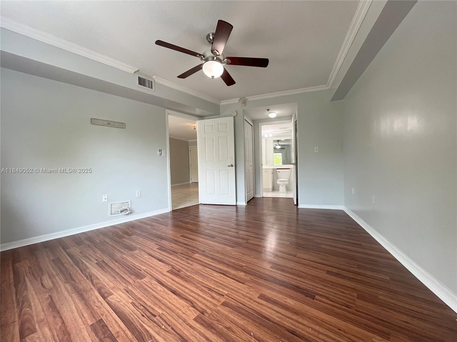 2415 Northwest 16th St Road, Unit 3031 Miami, FL 33125 - Photo 13 of 22 a view of an empty room with wooden floor and a ceiling fan