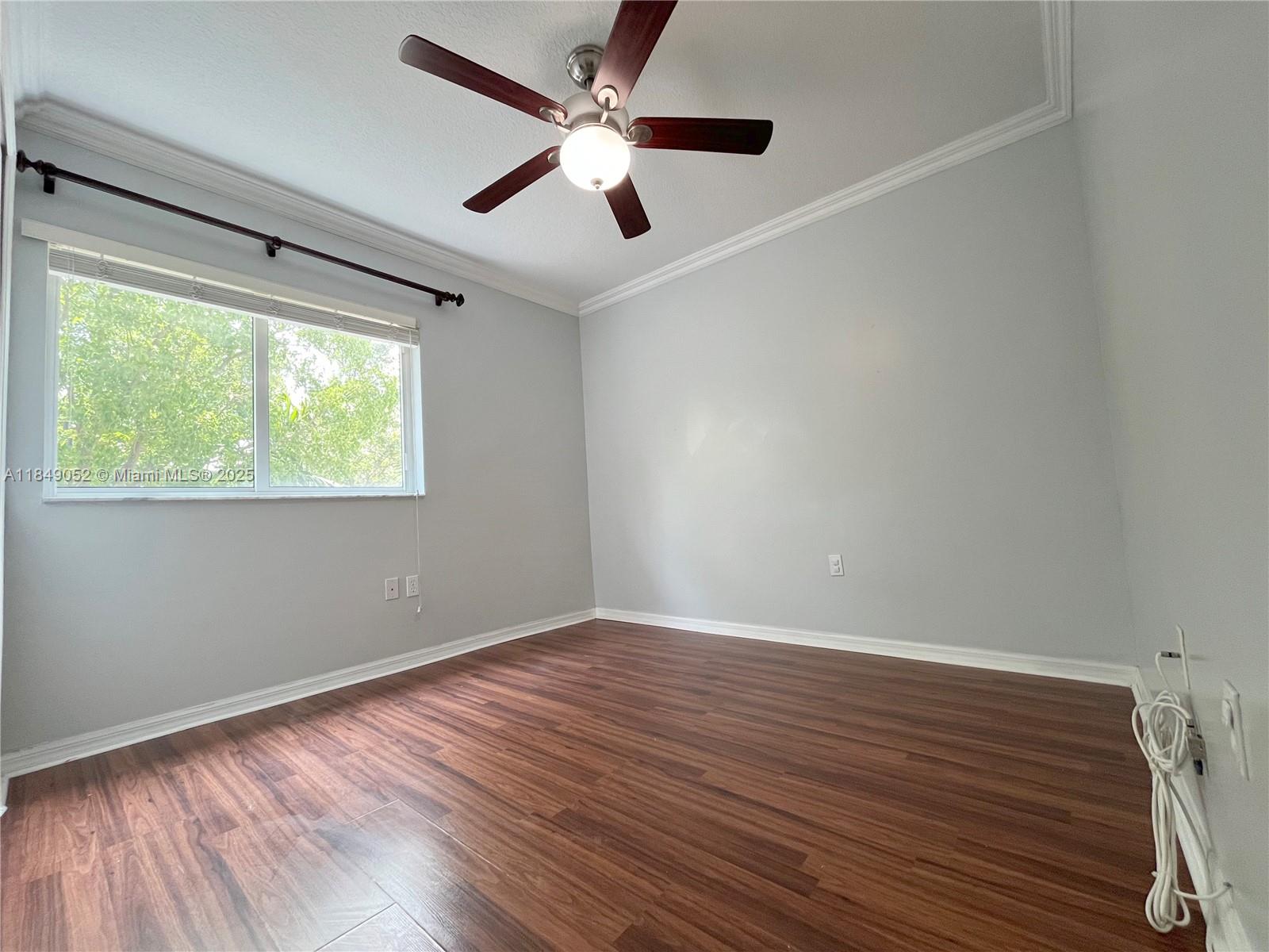 2415 Northwest 16th St Road, Unit 3031 Miami, FL 33125 - Photo 18 of 22 an empty room with wooden floor fan and windows