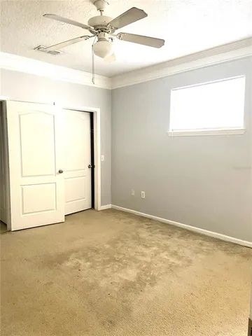 an empty room with a window and a ceiling fan