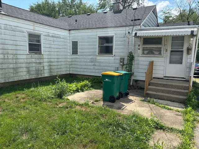 a view of a house with backyard and sitting area