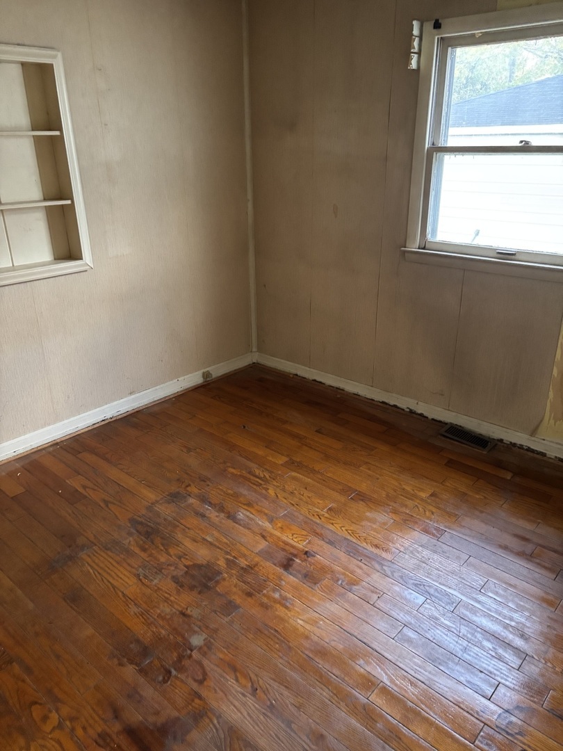 1010 Helen Avenue Joliet, IL 60433 - Photo 7 of 11 an empty room with wooden floor and windows