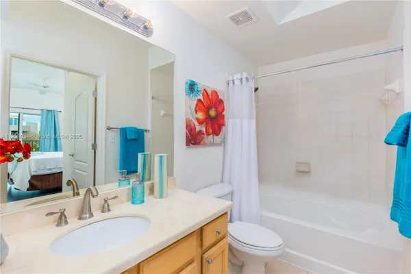 a bathroom with a sink a toilet and a large mirror