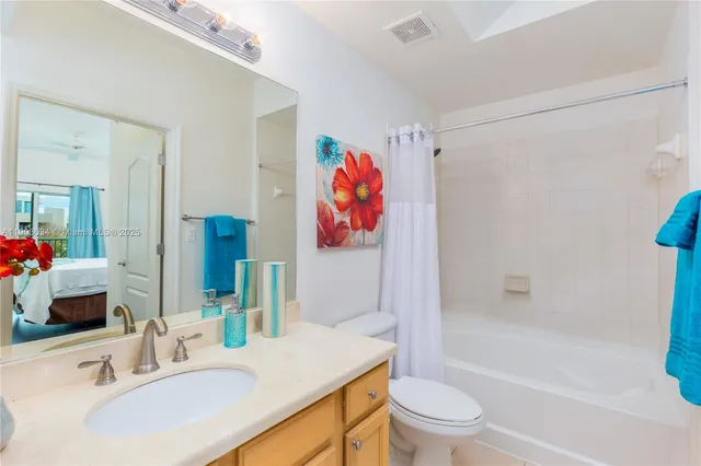 a bathroom with a sink a toilet and a large mirror
