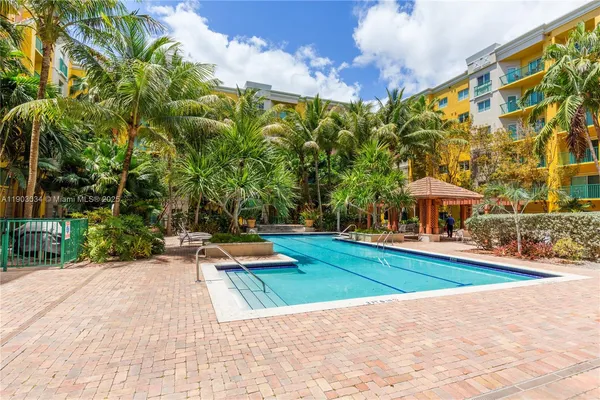 a view of swimming pool with lawn chairs and plants