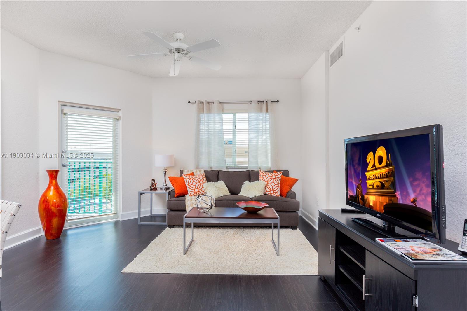 6001 Southwest 70th Street, Unit 610 South Miami, FL 33143 - Photo 2 of 18 a living room with furniture a flat screen tv and a window