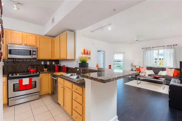 a kitchen with kitchen island granite countertop a stove and cabinets