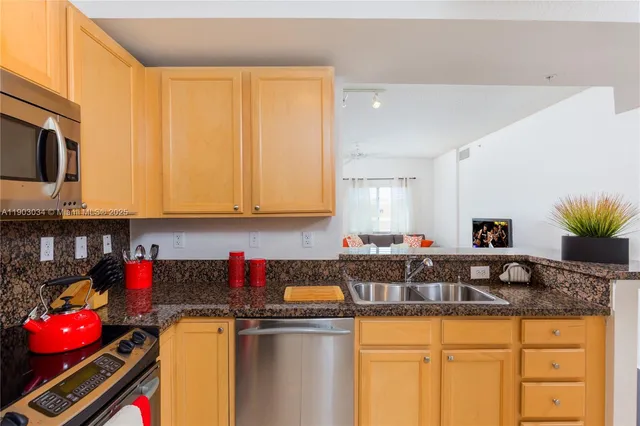 a kitchen with stainless steel appliances granite countertop a sink a stove and cabinets