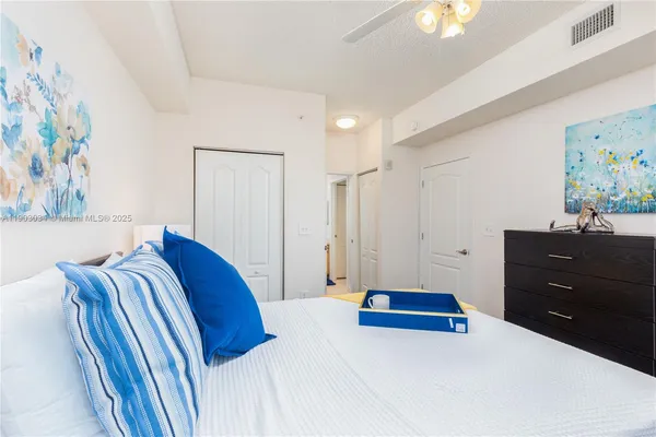 a bedroom with a bed and painting on the wall