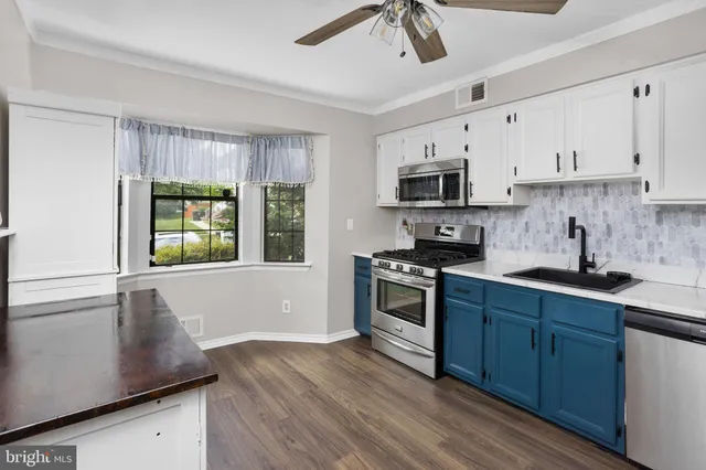 a kitchen with granite countertop a stove a sink and a refrigerator
