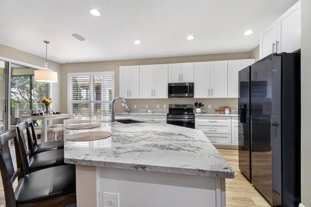 a spacious bathroom with a granite countertop sink mirror and a bathtub