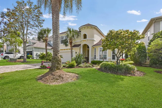 a kitchen with stainless steel appliances granite countertop a refrigerator a stove a sink a dining table and chairs with wooden floor