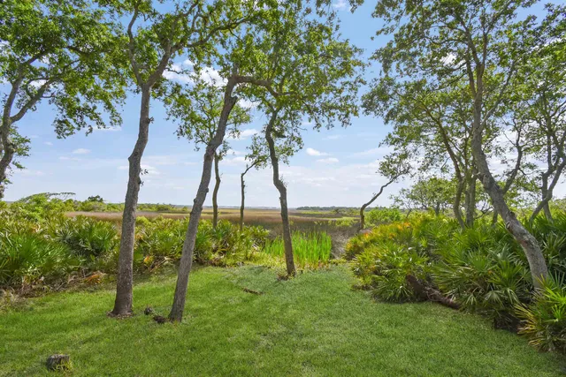 a view of a dining room and livingroom with furniture wooden floor a chandelier
