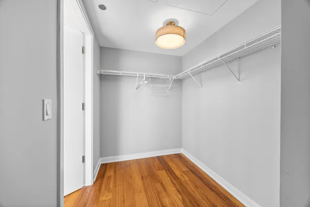a view of a room with a large window and wooden floor