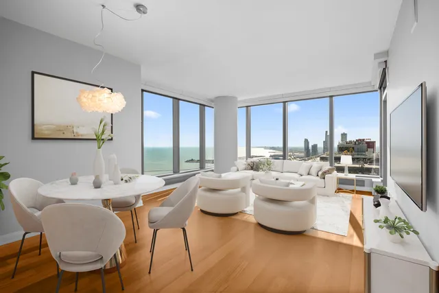 a dining room with furniture a large window and a flat screen tv