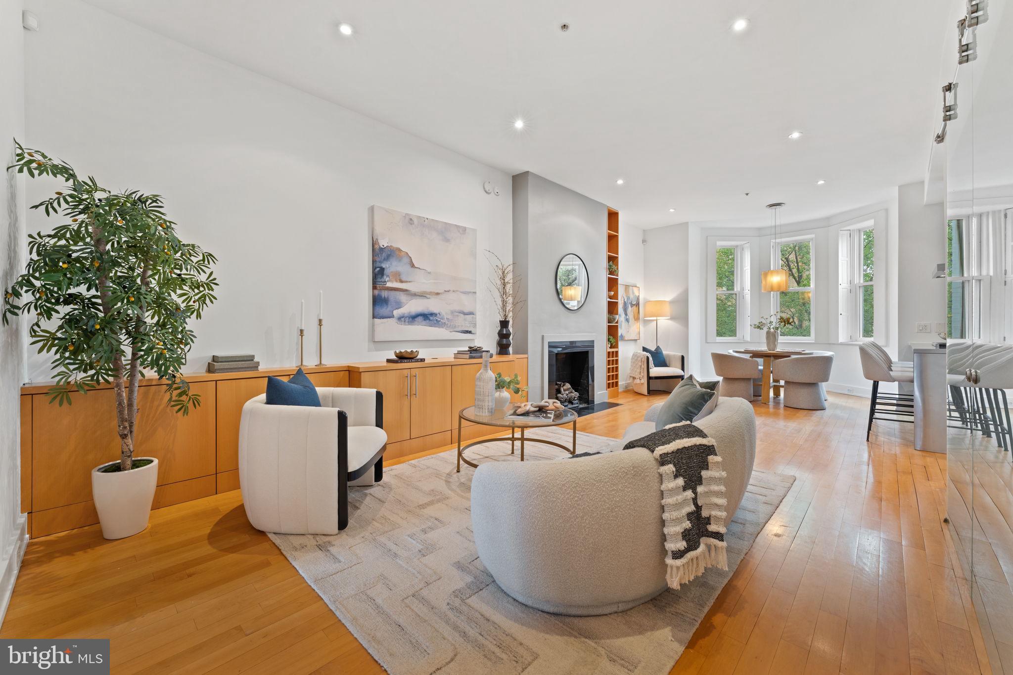 a living room with fireplace furniture and a large window