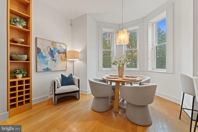 a living room with furniture a large window and dining table