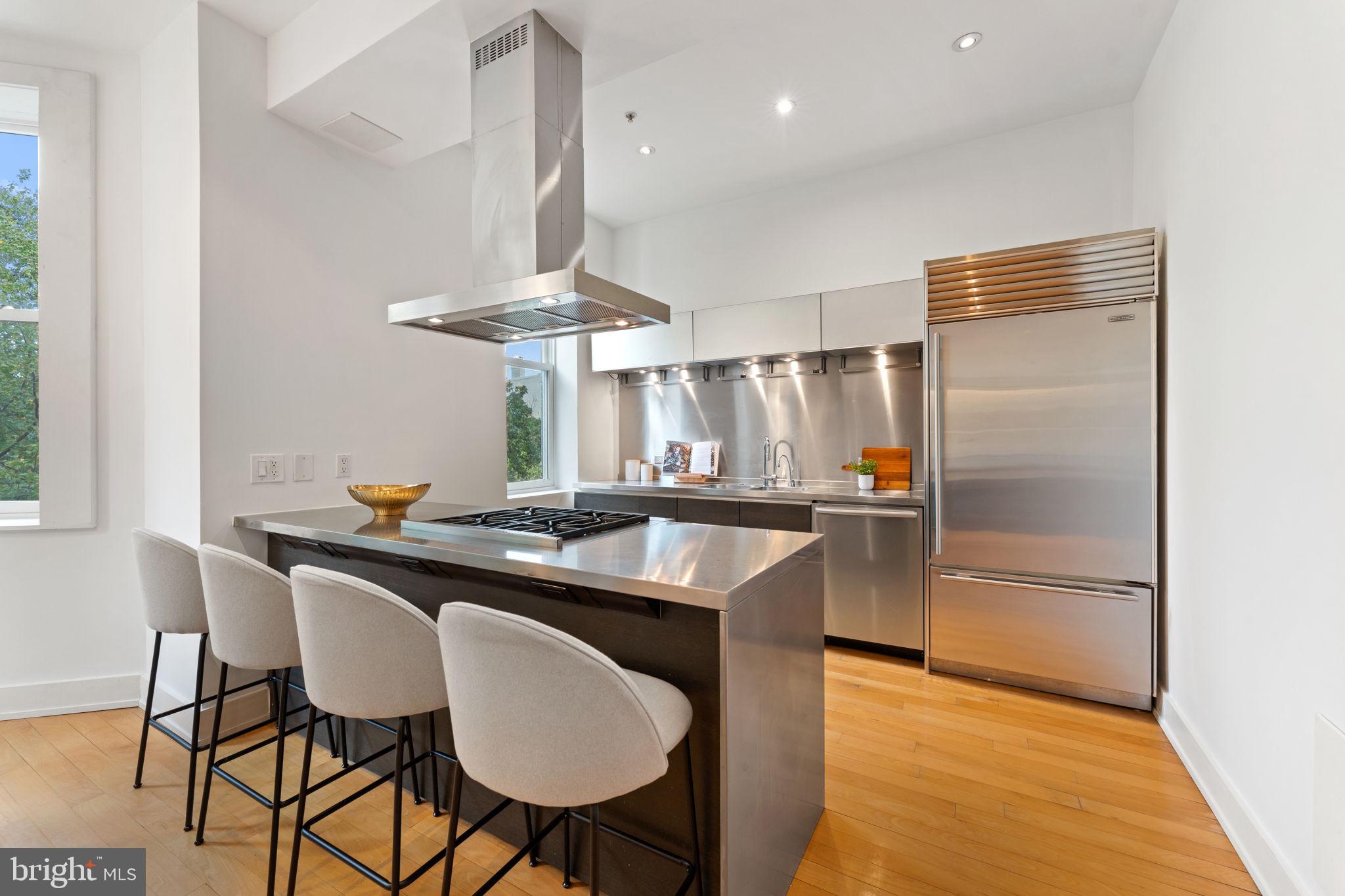 1516 R Street Northwest, Unit 3 Washington, DC 20009 - Photo 11 of 29 a kitchen with stainless steel appliances a table and chairs