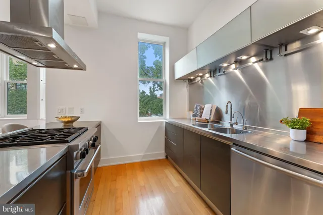 a kitchen with stainless steel appliances a table and chairs