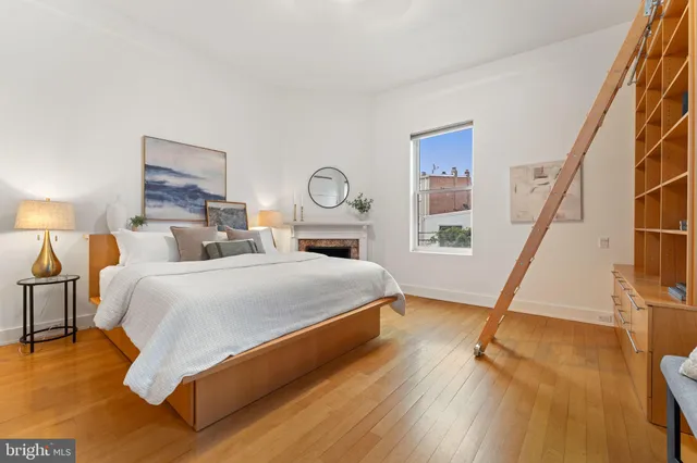 a view of a bedroom with bed and wooden floor