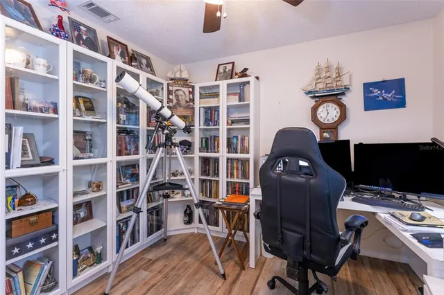 a view of a workspace with furniture and a bookshelf