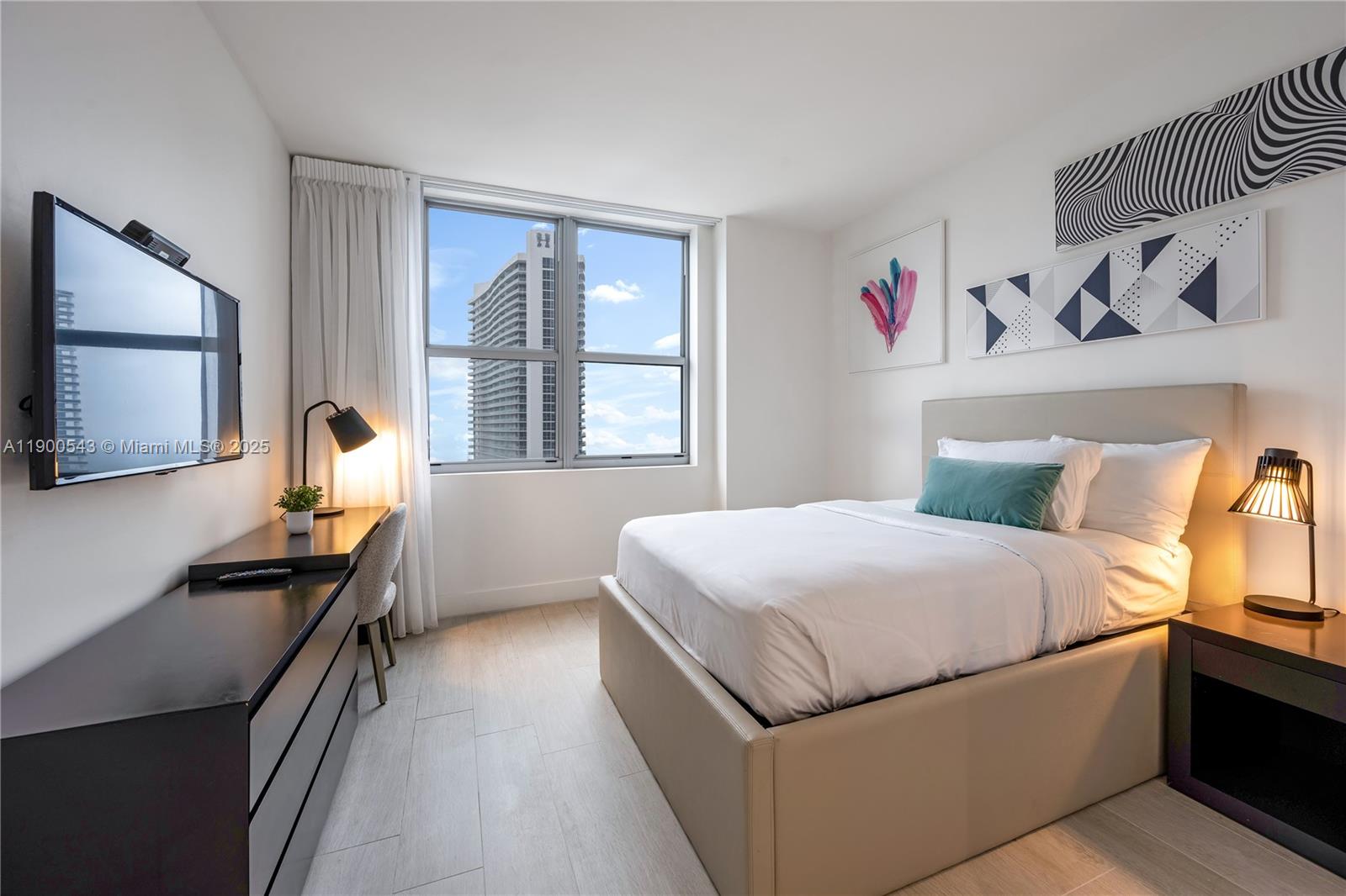 4010 South Ocean Drive, Unit R2501 Hollywood, FL 33019 - Photo 20 of 20 a bedroom with a bed and a dresser with mirror