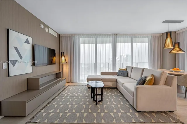 a living room with couches and kitchen view with wooden floor