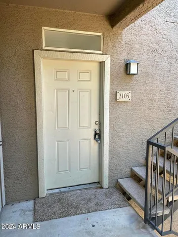 a view of a hallway with wooden door and stairs