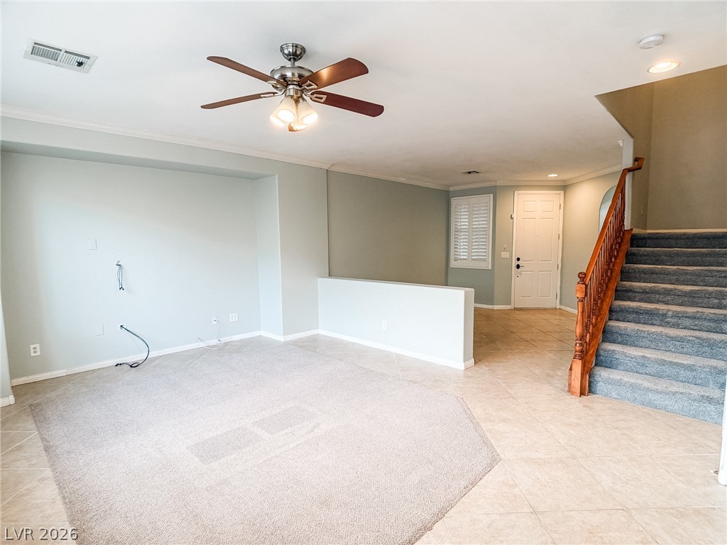 8683 Moreno Mountain Avenue Las Vegas, NV 89178 - Photo 4 of 26 A welcoming entryway with a traditional staircase and tile flooring flows into a carpeted living space.