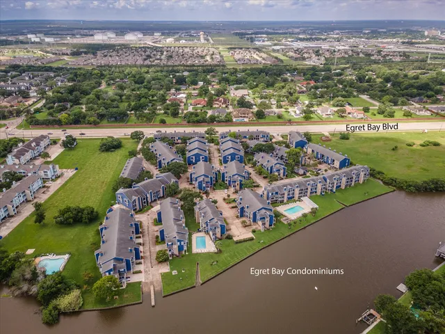 an aerial view of a city with lots of residential buildings ocean and mountain view in back