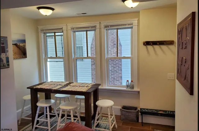 a living room with furniture a flat screen tv and kitchen view