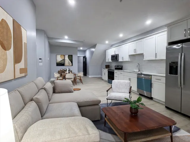 a living room with furniture kitchen view and a refrigerator