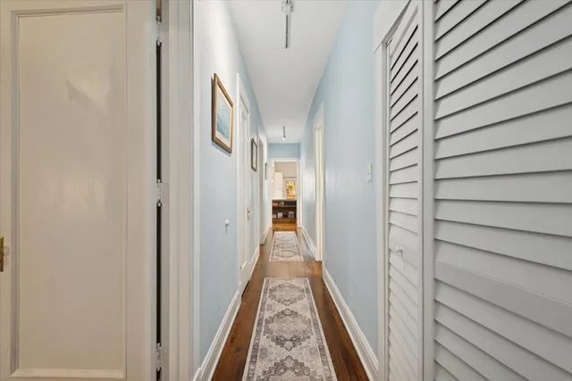 a view of a hallway with wooden floor and staircase