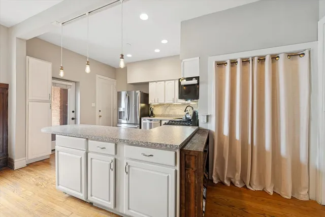 a kitchen with stainless steel appliances granite countertop a sink and a refrigerator