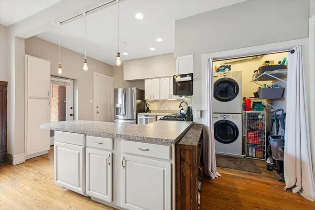 a view of a kitchen with a sink a washer and dryer