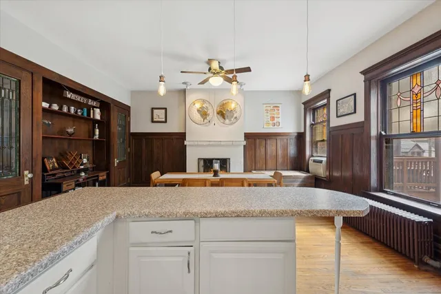 a kitchen with cabinets a counter top space stainless steel appliances and a chandelier