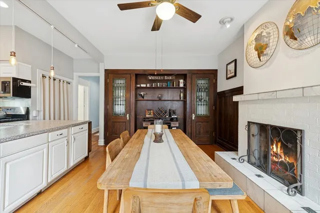 a large kitchen with stainless steel appliances granite countertop a stove top oven a sink dishwasher and a fireplace with wooden floor