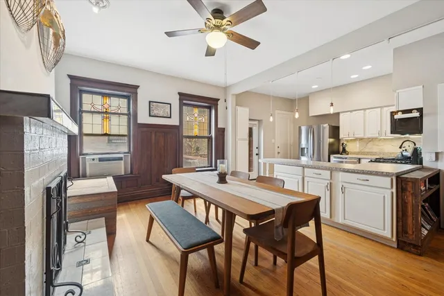 a kitchen with stainless steel appliances granite countertop a dining table chairs refrigerator and cabinets