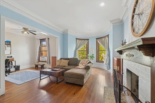 a living room with furniture a fireplace and a large window