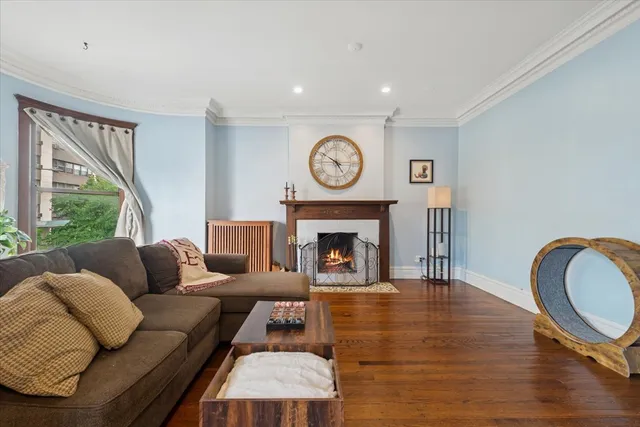 a living room with furniture a large window and a fireplace