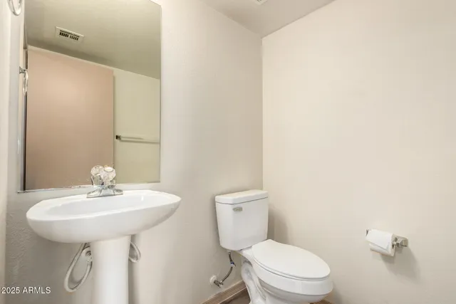 a bathroom with a sink a toilet and mirror