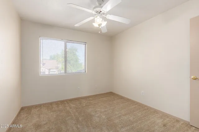 an empty room with a window and a fan